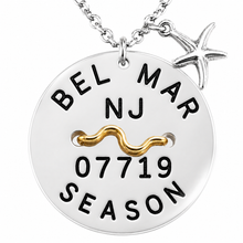 Load image into Gallery viewer, A silver round Belmar NJ Beach tag pendant necklace with a starfish charm, featuring a gold wavy bar across the center. The pendant is hand-stamped with 'BEL MAR NJ 07719 SEASON' in black lettering.
