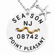 Load image into Gallery viewer, A silver round pendant beach tag necklace engraved with 'SEASON NJ 08742 POINT PLEASANT' and a gold wave detail, featuring a small silver starfish charm on a white background.