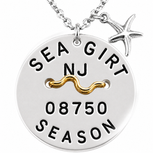 Load image into Gallery viewer, A silver round pendant beach tag necklace with a starfish charm, featuring a gold wave accent and black engraved text that reads 'SEA GIRT NJ 08750 SEASON'.