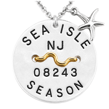 Load image into Gallery viewer, A silver round beach tag pendant necklace with a starfish charm and a gold wavy accent, featuring the text 'SEA ISLE NJ 08243 SEASON'.