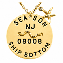 Load image into Gallery viewer, A gold-toned round bech tag pendant necklace on a chain, featuring a starfish charm. The pendant is hand-stamped with the text 'SEA SON', 'NJ', '08008', and 'SHIP BOTTOM' along with a wave symbol, shown on a plain white background.