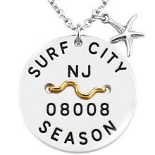 Load image into Gallery viewer, A silver round beach tag pendant necklace with 'SURF CITY NJ 08008 SEASON' engraved, featuring a gold wavy accent and a dangling silver starfish charm, shown on a white background.