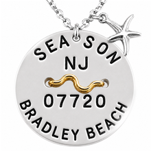 Load image into Gallery viewer, A silver round beach tag pendant necklace engraved with 'SEA SON NJ 07720 BRADLEY BEACH' and a wavy gold accent, shown with a starfish charm on a white background.
