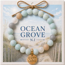 Load image into Gallery viewer, Carded Ocean Grove Goldtone Beach Tag Amazonite Beaded Bracelet with twine bow
