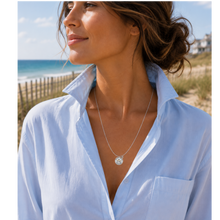 Load image into Gallery viewer, A woman at the beach wearing a necklace that has a starfish and beach badge pendant of Ocean Grove, NJ
