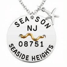 Load image into Gallery viewer, A silver round beach tag pendant necklace engraved with 'SEASON NJ 08751 SEASIDE HEIGHTS' and a gold wavy accent, featuring a silver starfish charm on a white background.
