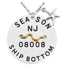 Load image into Gallery viewer, A silver round beach tag pendant necklace with a starfish charm and a gold wave accent, featuring the text 'SEA SON NJ 08008 SHIP BOTTOM' on a white background.
