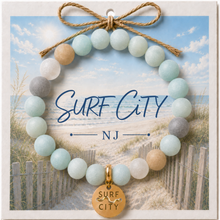 Load image into Gallery viewer, Carded Surf City Goldtone Beach Tag Amazonite Beaded Bracelet with twine bow
